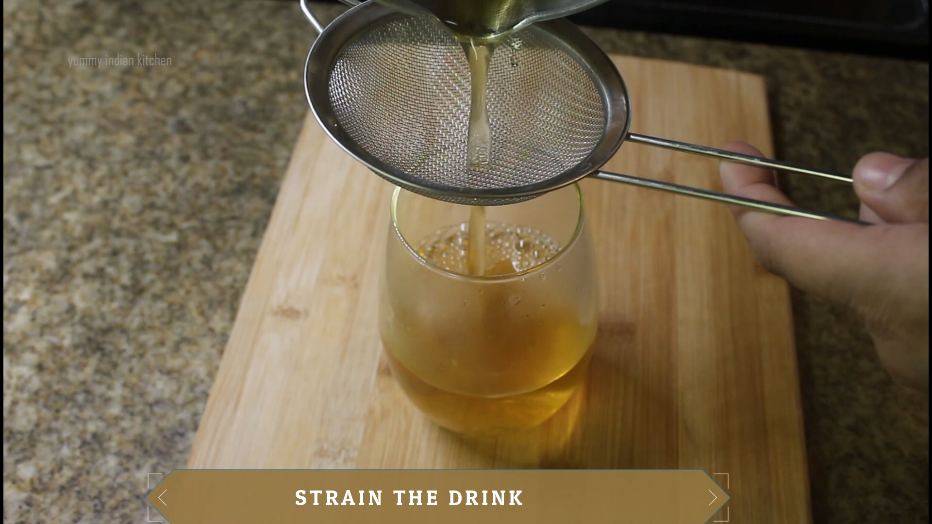 straining the jeera water into the glass 