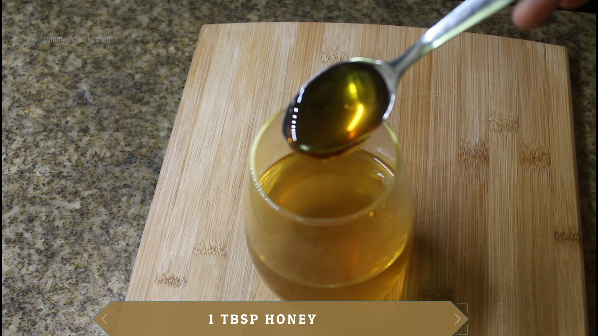 adding a teaspoon of honey to the water in glass