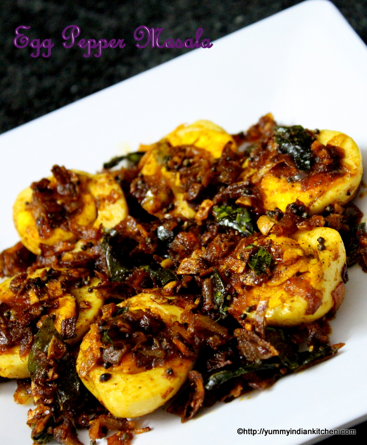 old picture of egg pepper fry where boiled eggs into halves are spread on a plate with onion masala on top