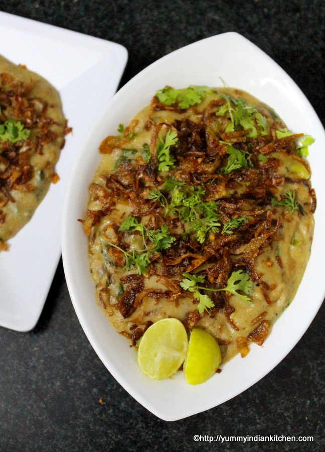 haleem recipe served in a bowl with fried onions and lemon as topping