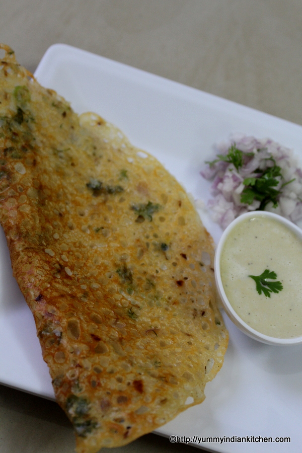 instant rava dosa on a plate with chutney in a small bowl