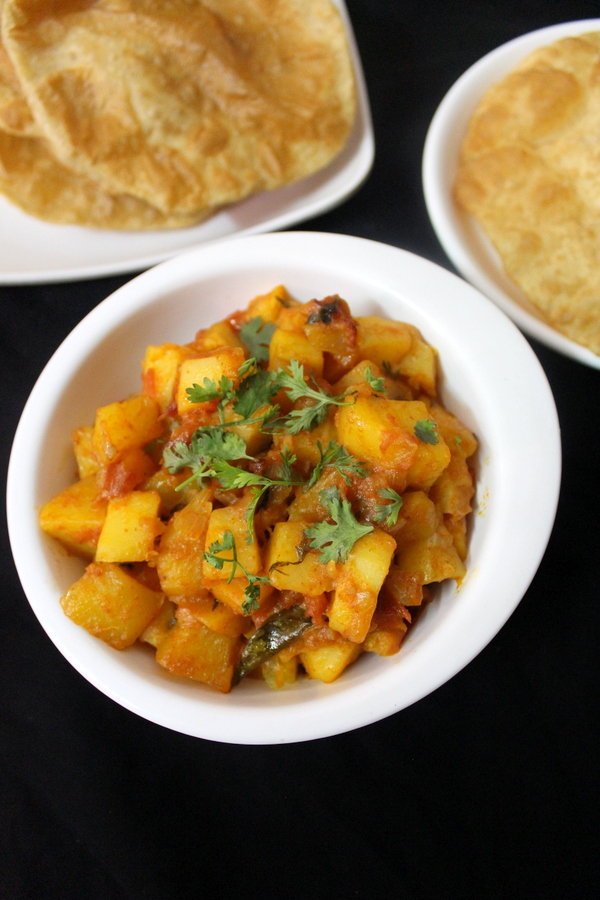 aloo curry recipe and poori placed beside 