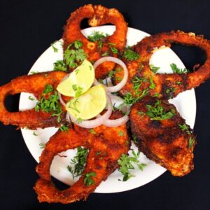 fish fry masala on a plate with onions and lemon