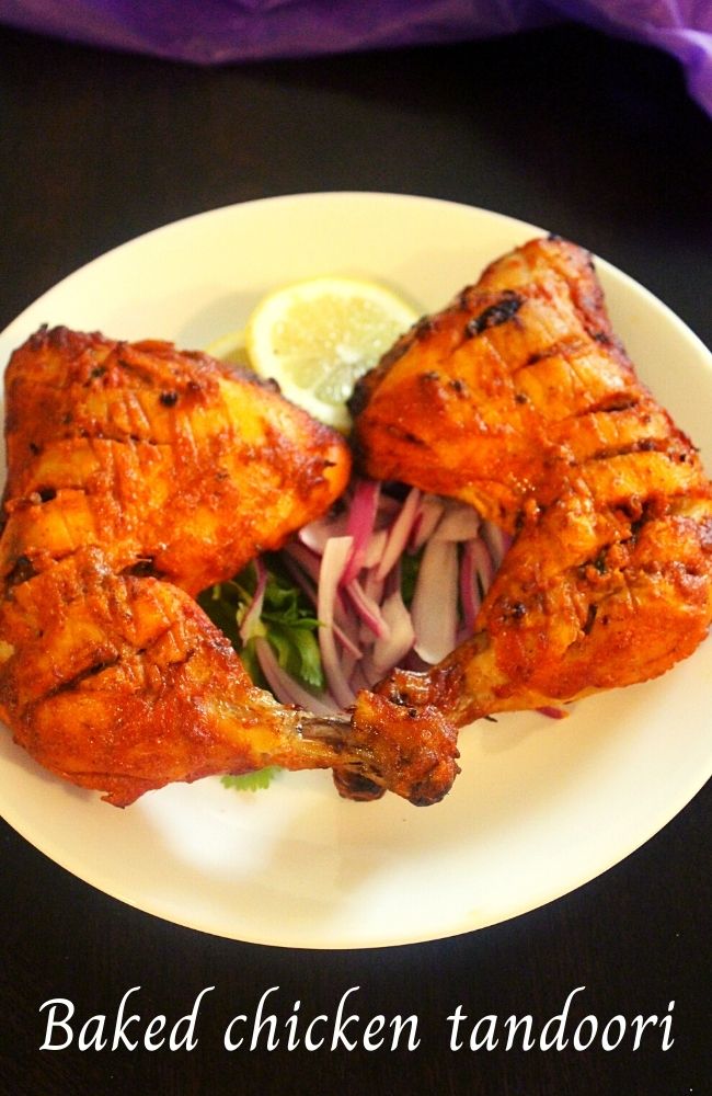 chicken tandoori in oven garnished with onions and lemon