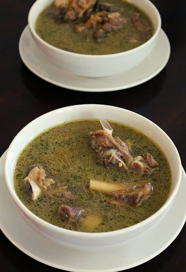 mutton soup placed in two serving bowls with mutton on the soup