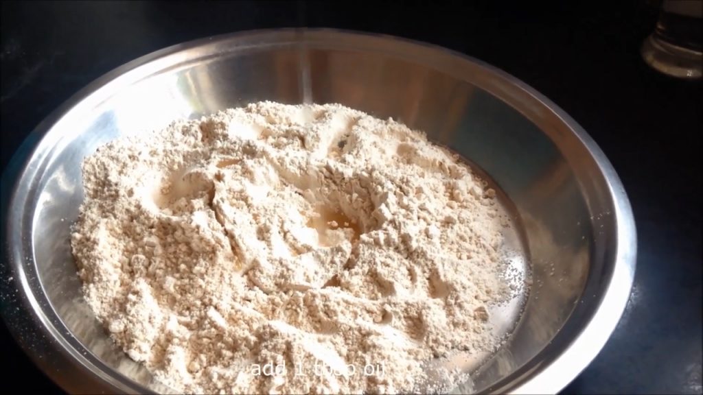 Adding oil onto the flour and mix it well with the flour