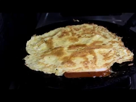 cooking by flipping bread pieces to the omelette 