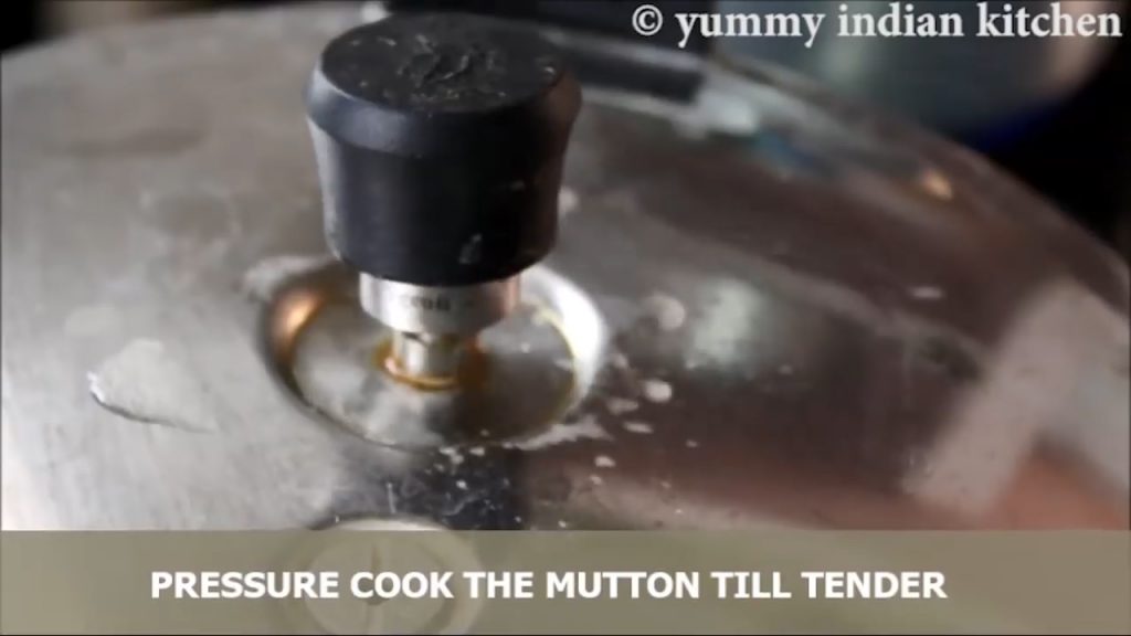 pressure cooker showing whistle to pressure cook