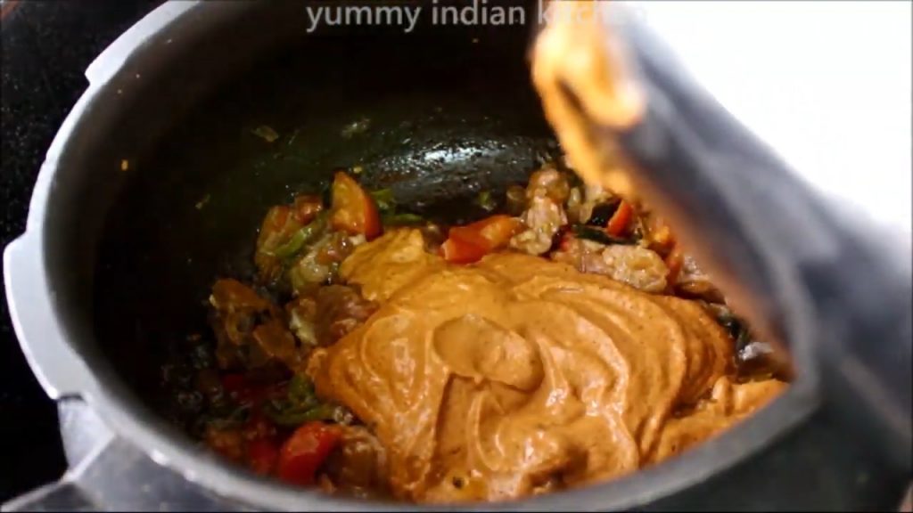 Adding the blended masala paste from the jar to make mutton kuzhambu