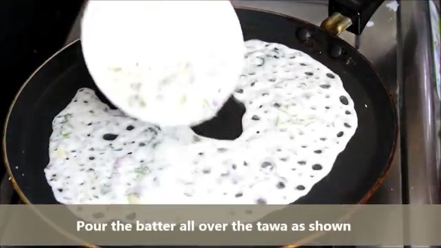 take a bowl full of batter and pour the thin batter all over the tawa.
