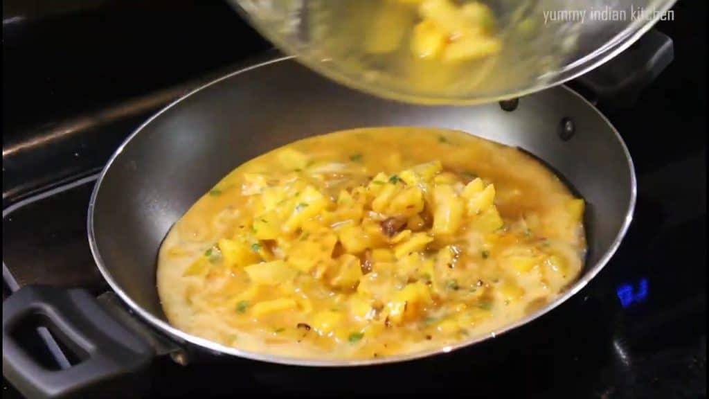 spreading the egg potato mixture to make potato omelette