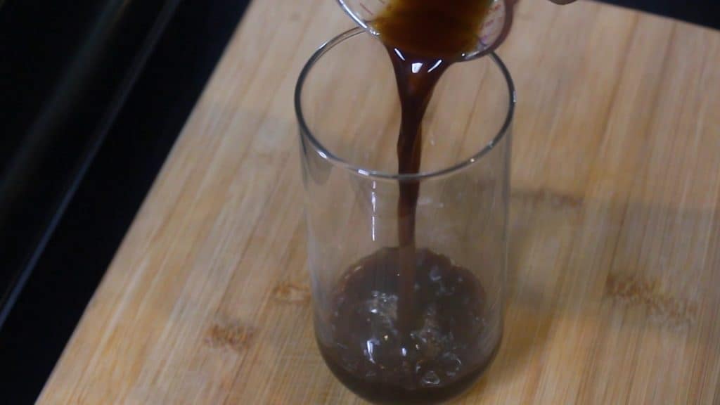 pouring brewed espresso in a coffee glass