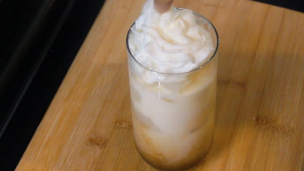 topping the iced vanilla latte starbucks with whipping cream