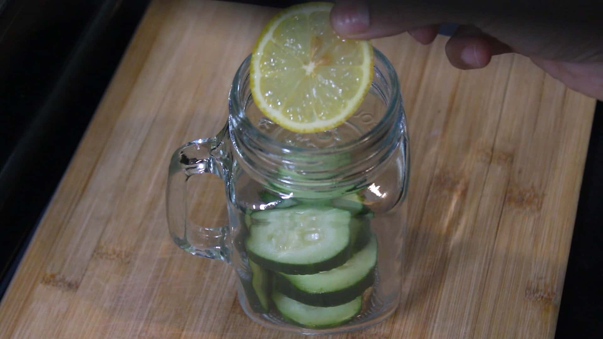 adding lemon slices into a jar