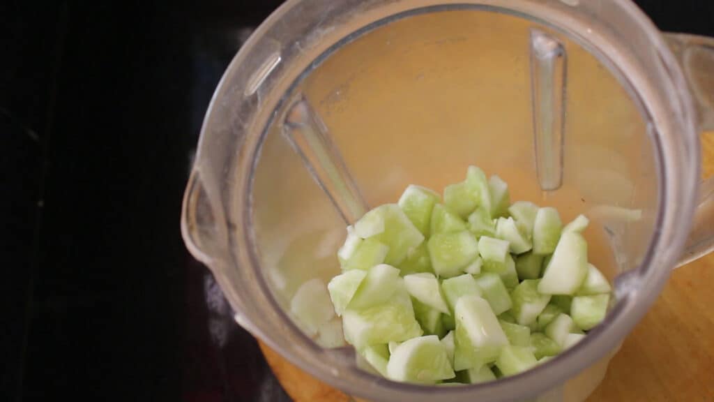 showing added cucumber pieces in a jar