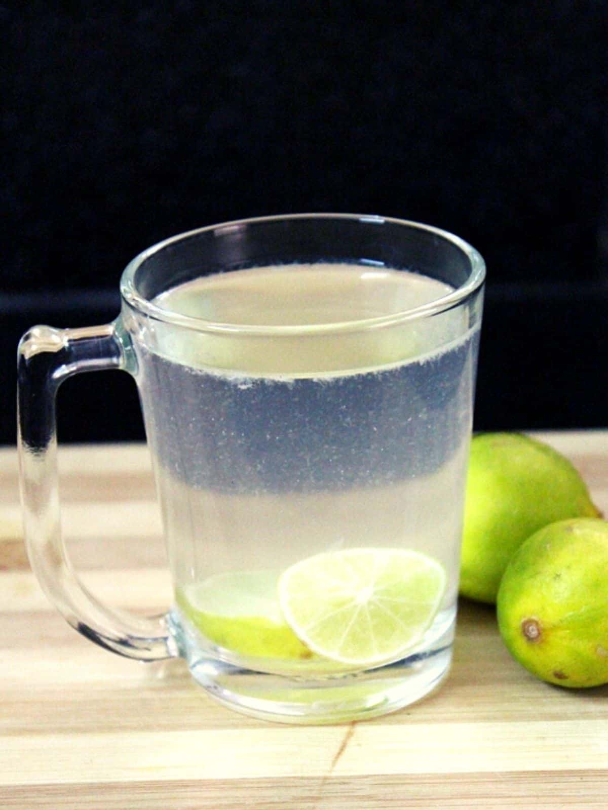 lemon water in a glass with lemon slices inside
