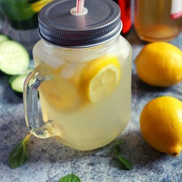 apple cider vinegar and lemon juice mixed in water and served in a mason jar to drink