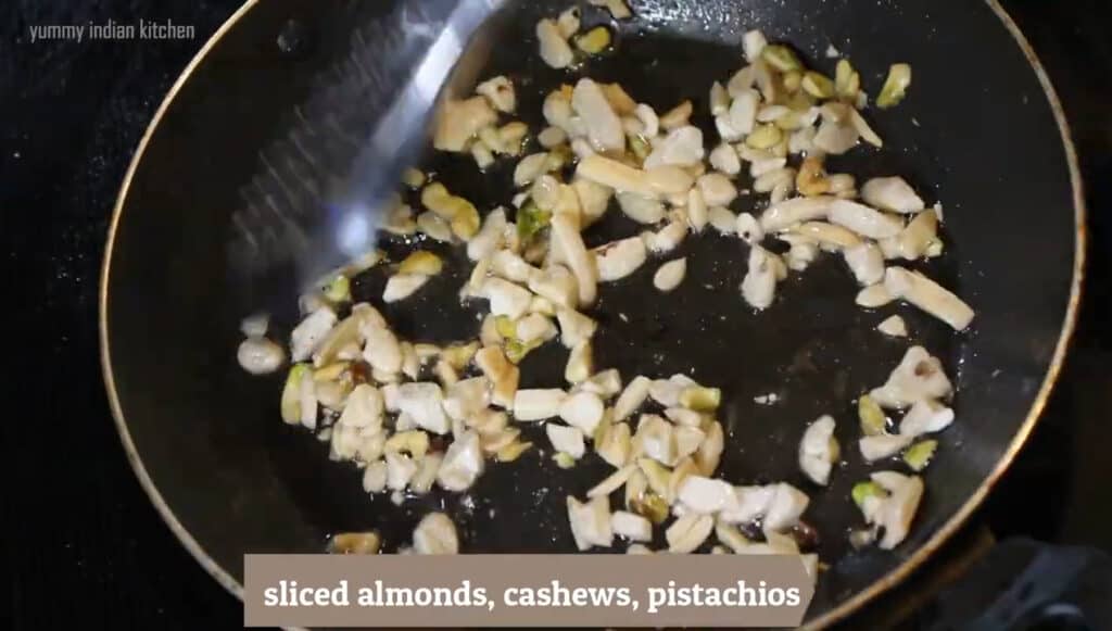 Sauteing sliced cashews, sliced almonds and sliced pista in ghee