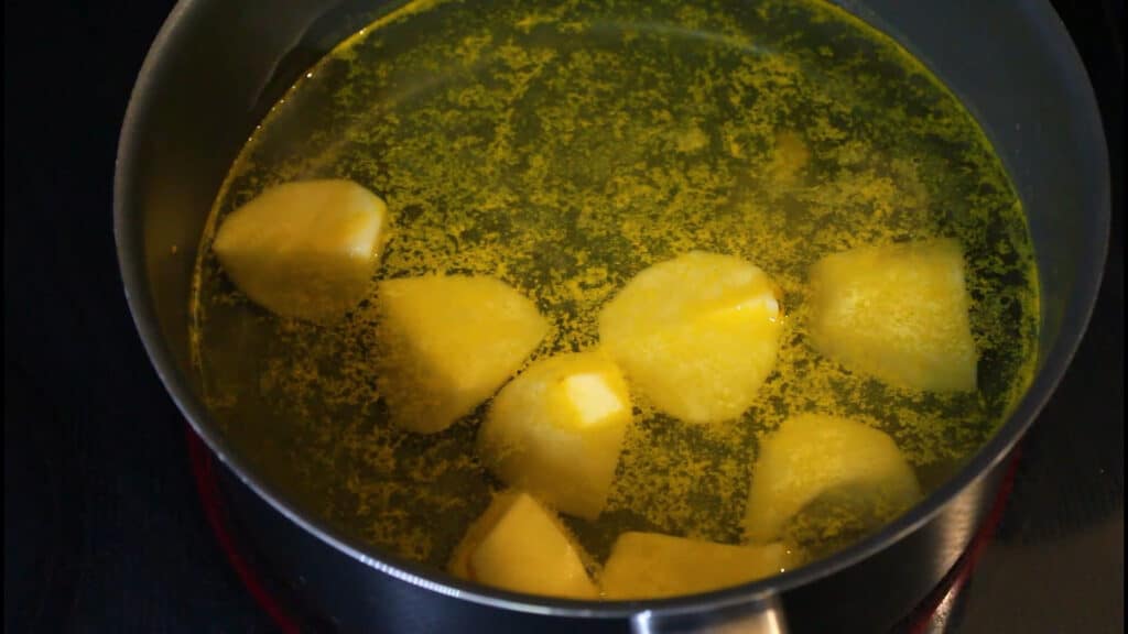 boiling the peeled and cut potatoes into the water until they are half done or 50% cooked