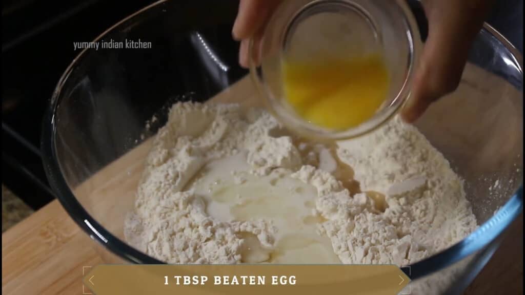 Adding milk into it, oil, and 2 teaspoons of beaten egg 