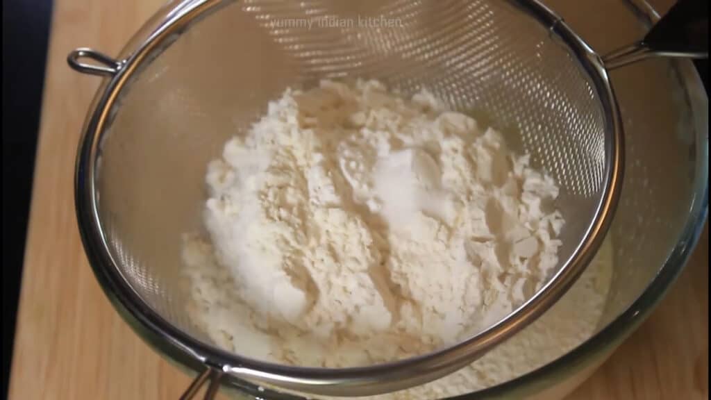 adding flour into the sieve, baking powder and a pinch of salt 