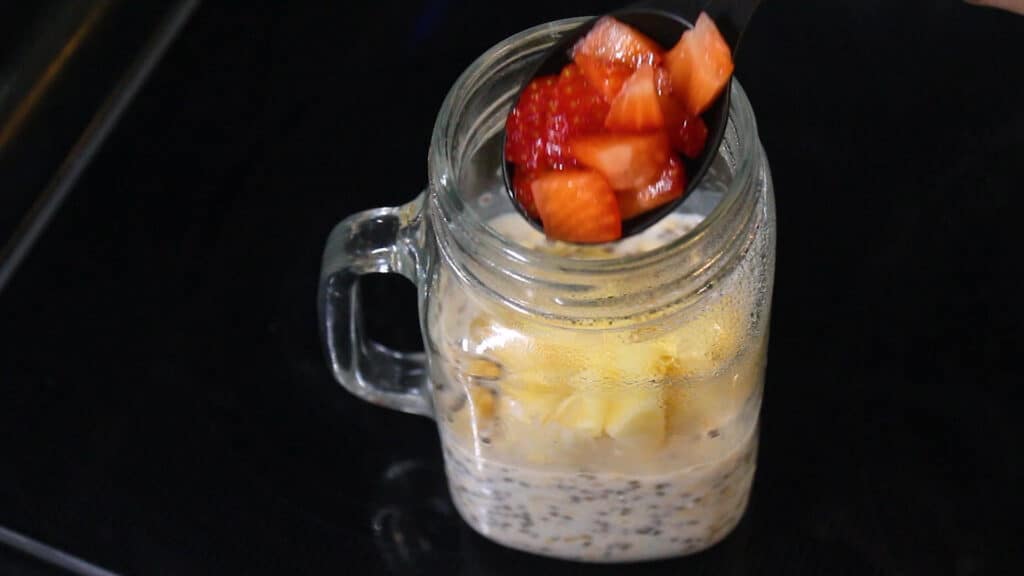 adding chopped fruits to healthy overnight oats