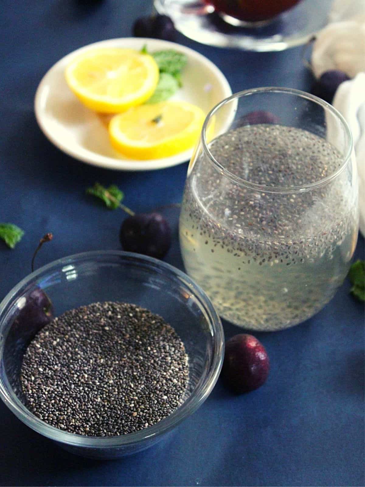 chia seeds drink for weight loss served in a glass with lemon slices and chia seeds beside