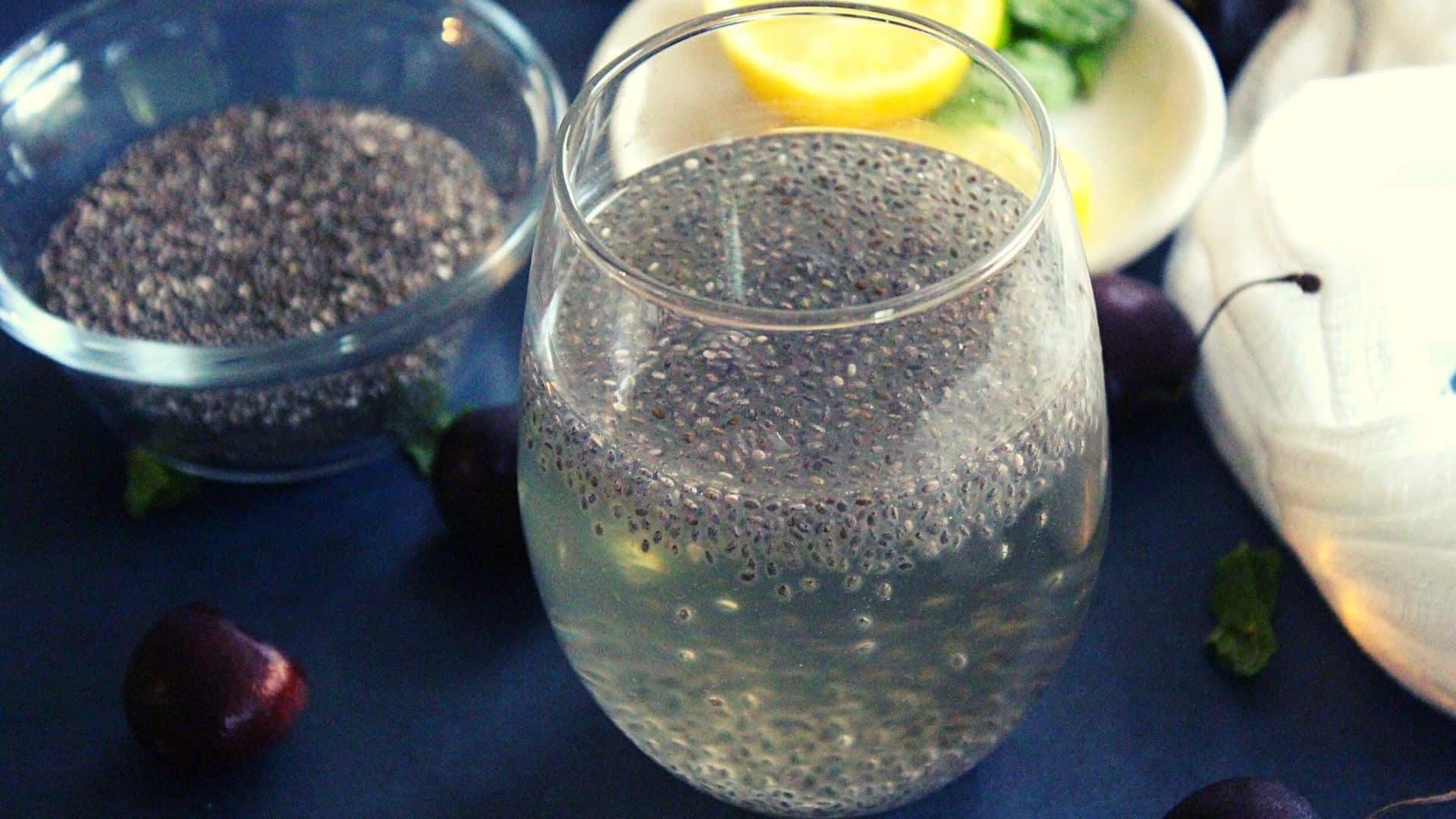 chia seeds drink for weight loss served in a glass with lemon slices and chia seeds beside