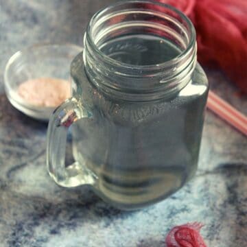 salt water in small jar with pink salt placed beside