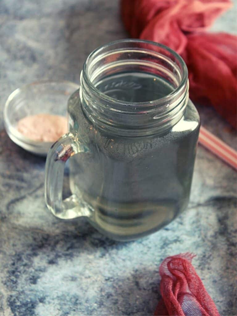 salt water in small jar with pink salt placed beside
