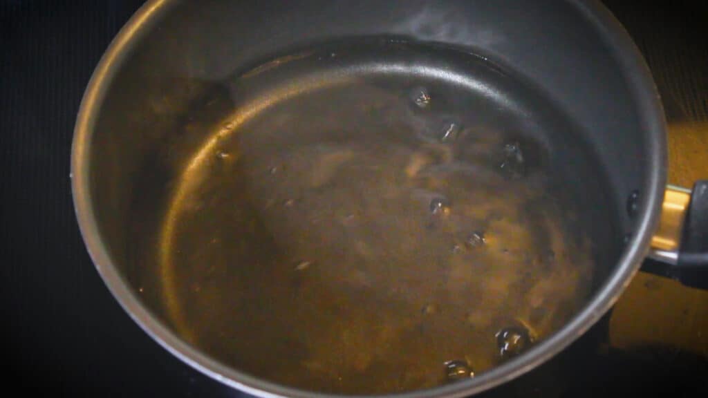 Pouring water into a saucepan to make chai tea