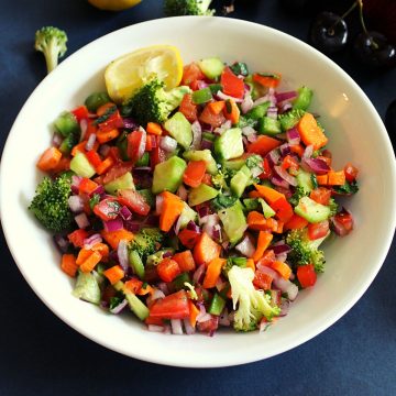 veg salad with mixed veggies in a bowl with garnishing spread beside