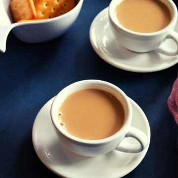 irani chai or irani tea served in tea cups along with biscuits