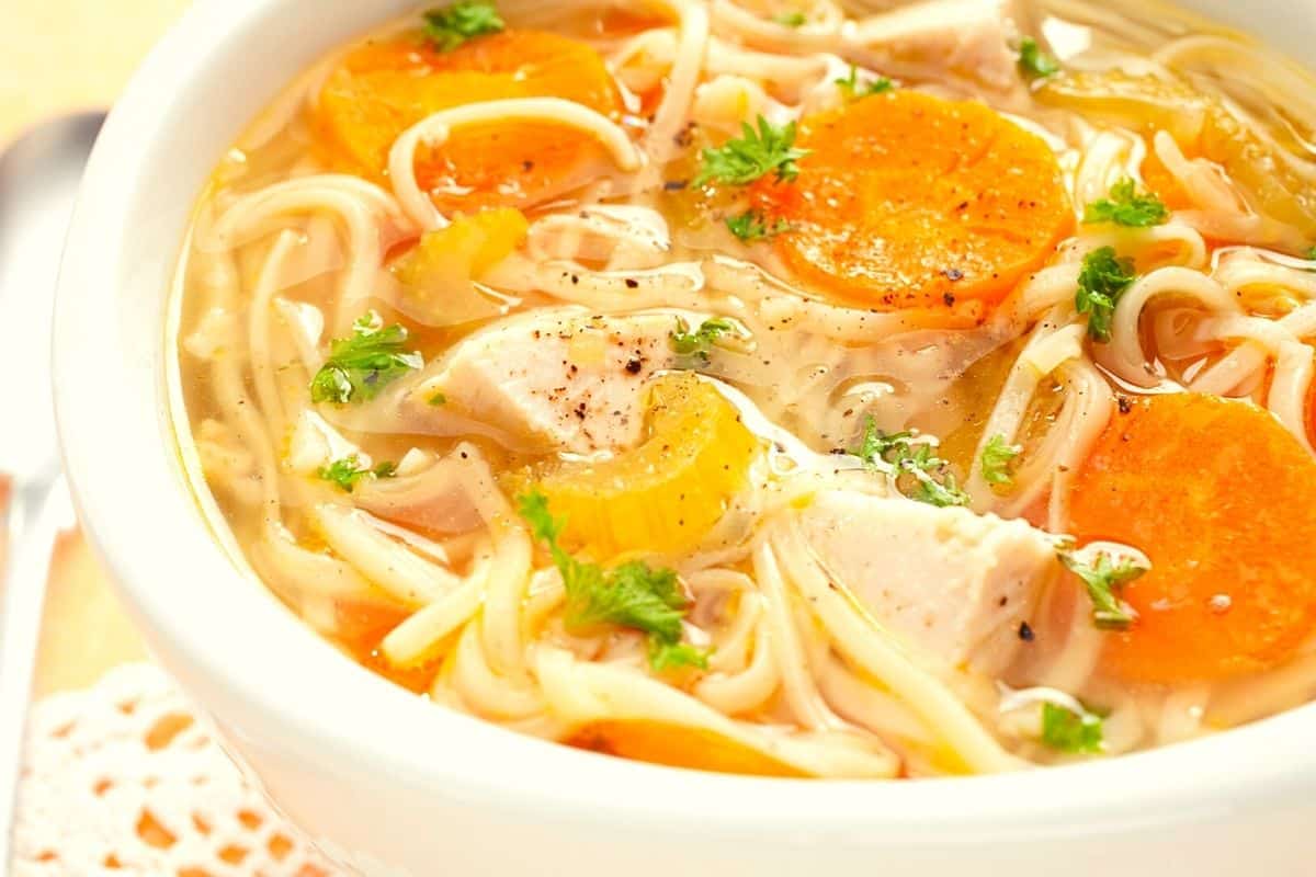 chicken and wheat noodles in a bowl pf soup