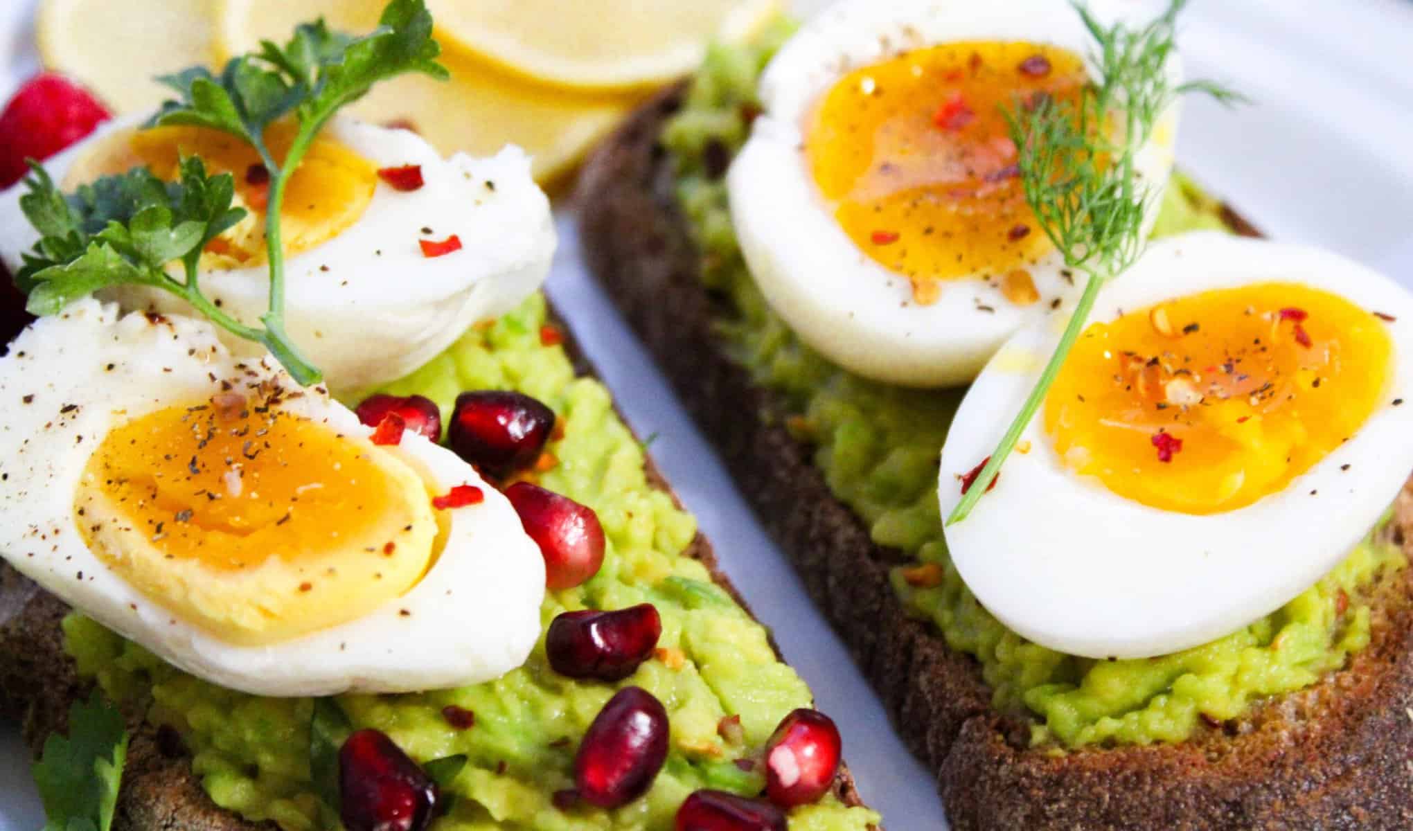 Boiled eggs placed on avocado toast for a healthy breakfast