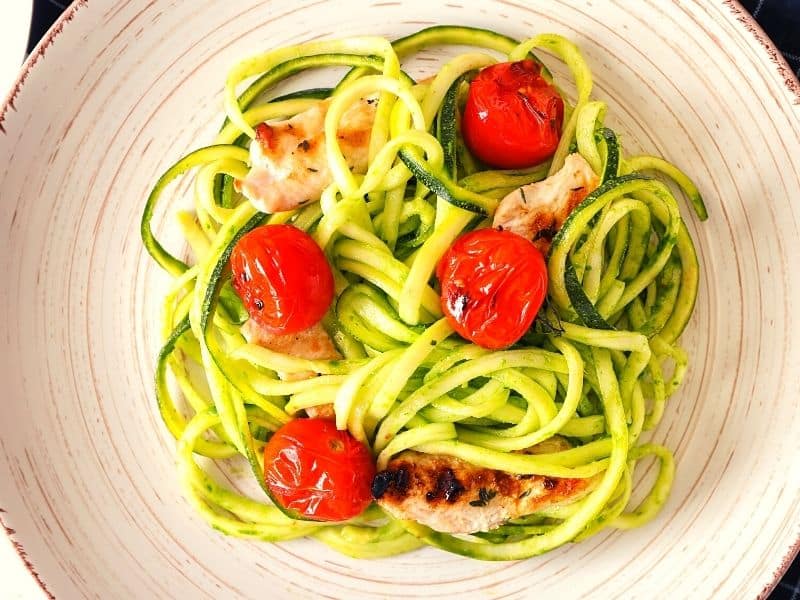 zoodles and cooked chicken with cherry tomatoes on top