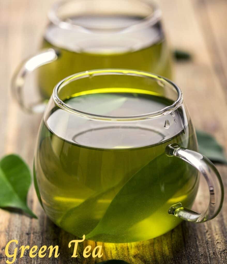 green tea in two different cups on a board