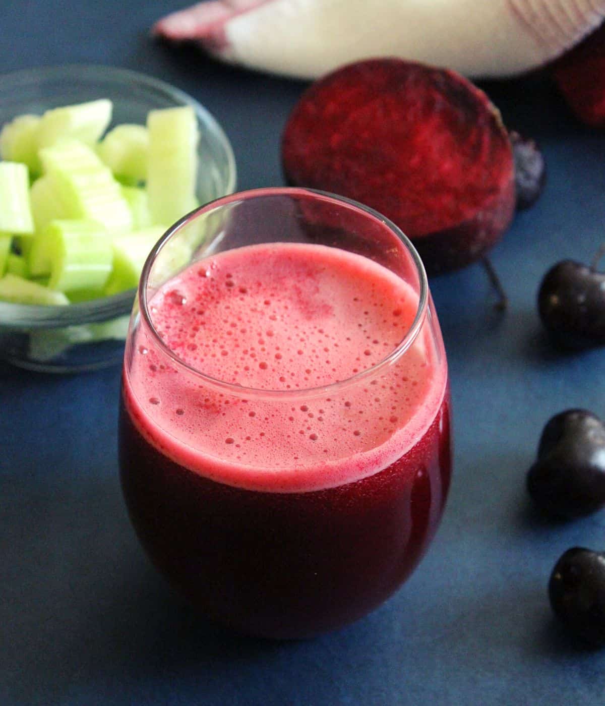 liver detox drink in a glas with celery , cherries and beetroot beside in the backgraound