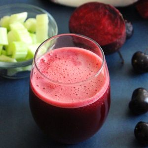 liver detox drink in a glas with celery and beetroot beside in the backgraound