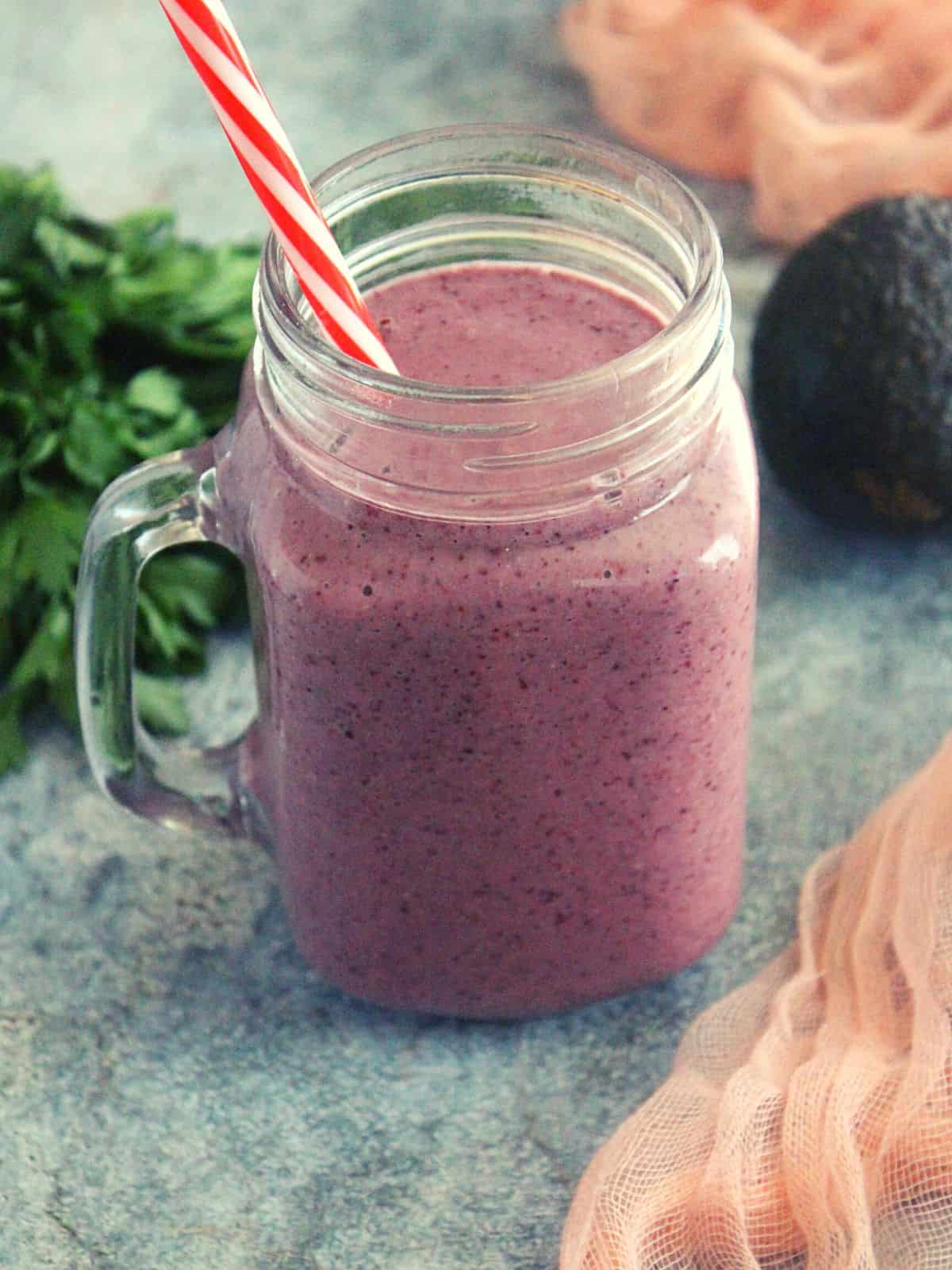 weight loss breakfast smoothie in a mason jar with avocado and greens shown as garnishing