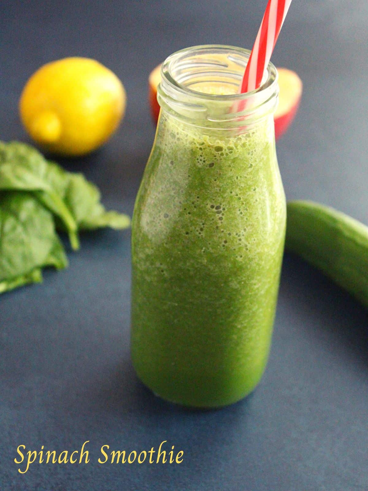 weight loss spinach smoothie in a smoothie bottle with a straw and lemon and apple beside the bottle