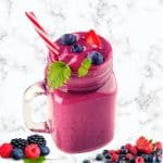 frozen fruit smoothie in a mason jar made using berries and served with a straw