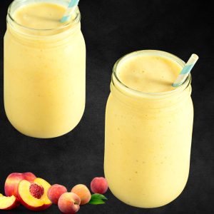 peach smoothie with yogurt in mason jars and peaches around