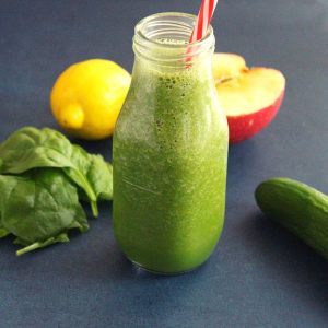 weight loss spinach smoothie in a smoothie bottle with a straw and lemon and apple beside the bottle