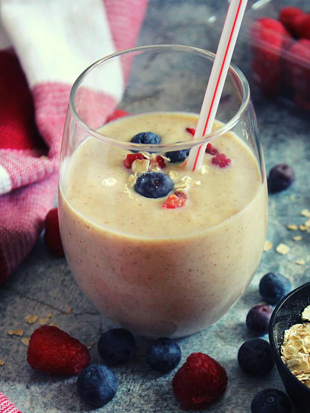 oats weight loss smoothie in a glass with colorful berries around