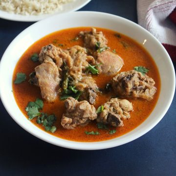 Indian coconut chicken curry served in a bowl with a bowl of rice