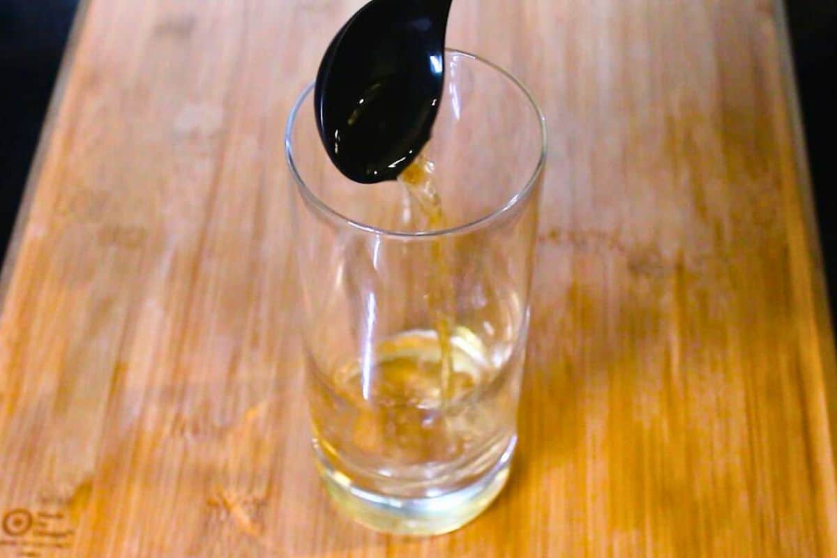 adding apple cider vinegar to a glass