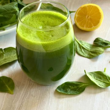 fresh spinach juice in the glass with garnishing around